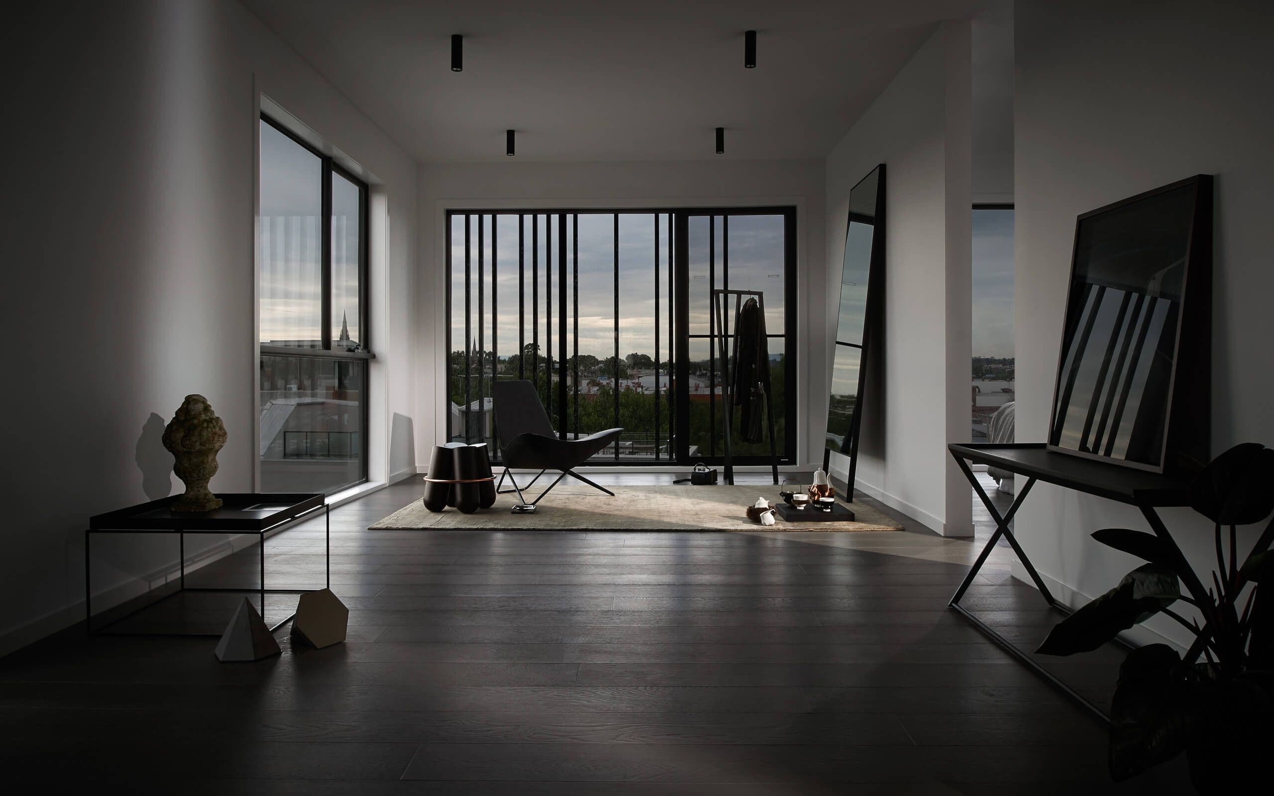 Curated shadowed view of the whole room, dark mirrors, furniture and items