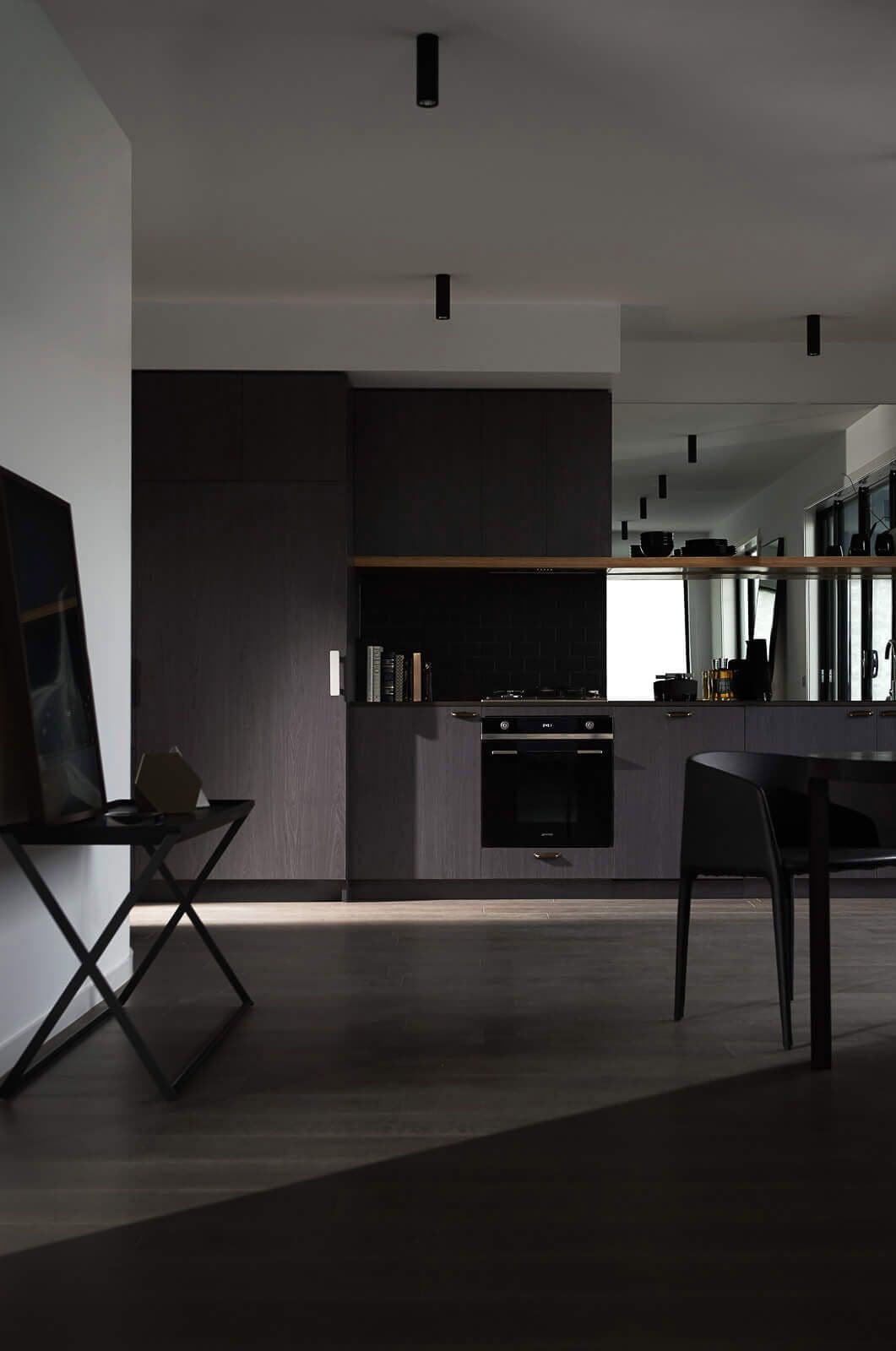 View towards the kitchen with dark colors and textures