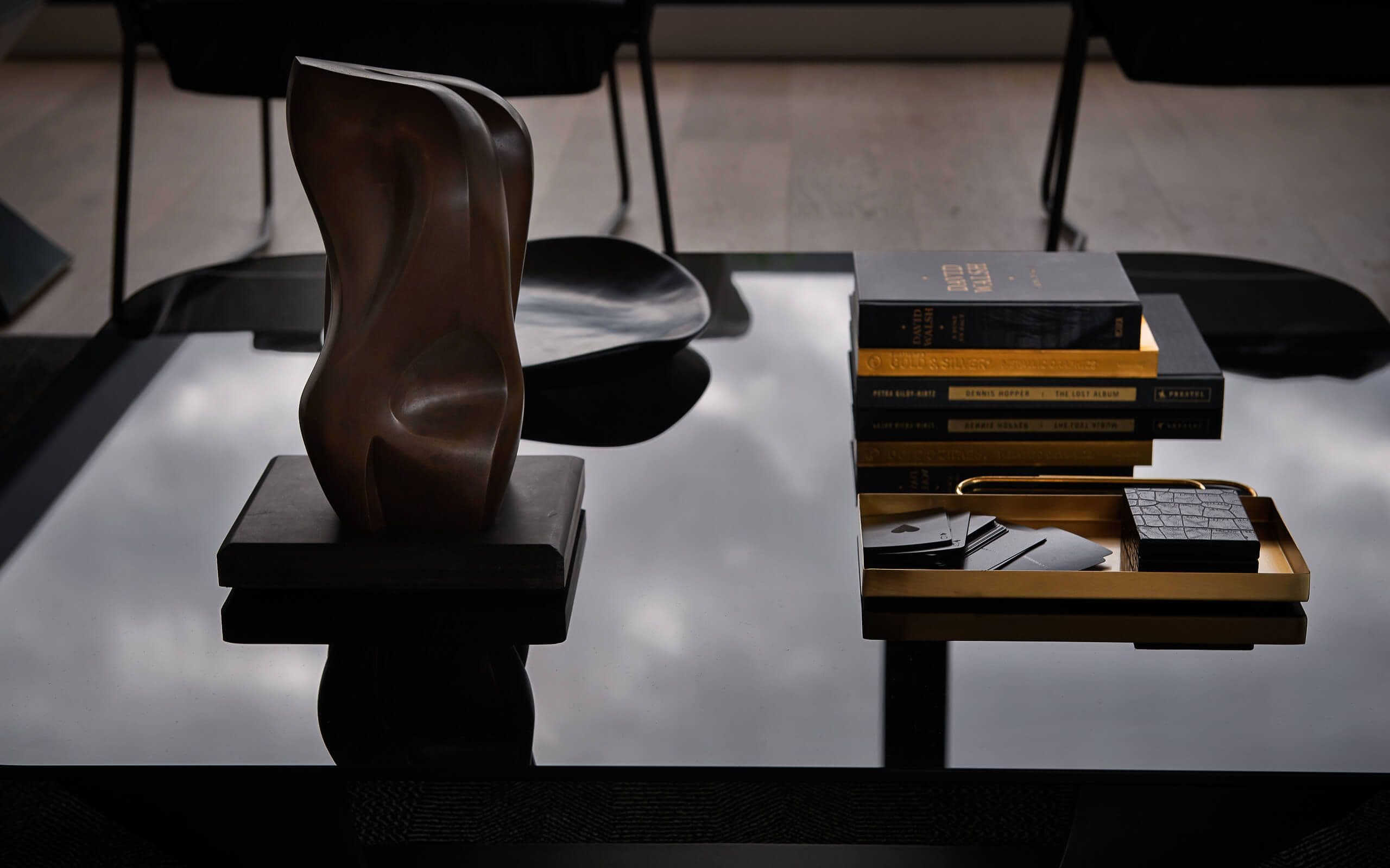 Items on a dark glass table, reflecting the clouds