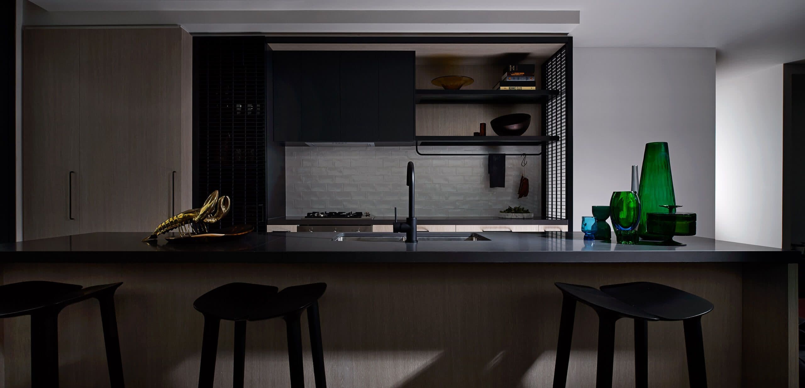 Wide photo over a dining table of the kitchen in dark tones