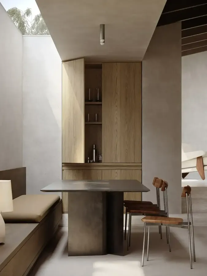 Bespoke curated dining space, with pale wooden cupboards and filtered light from above